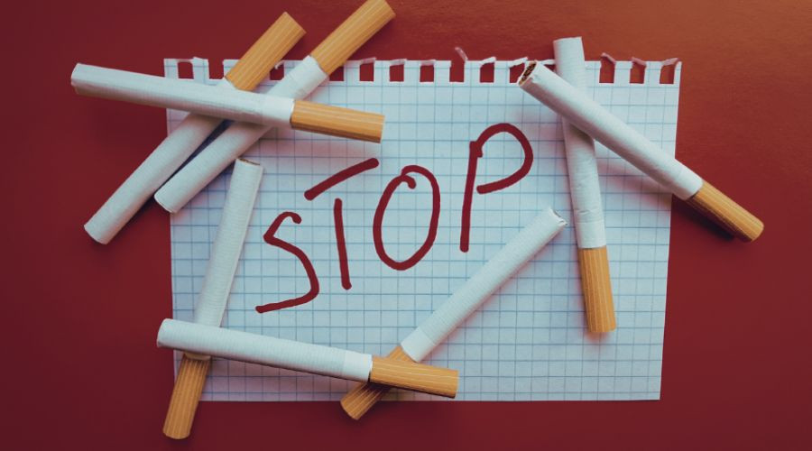 cigarettes on top of piece of paper that says 'stop'