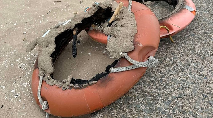 Fire-damaged life rings left behind on a beach in Wirral after being vandalised