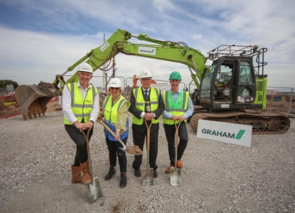 Representatives break ground in front of a digger at Miller's Quay