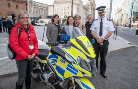 Six people, including representatives from Wirral and the Police, stood by a Police bike in Liverpool