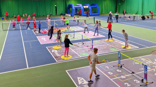people using indoor courts to play tennis