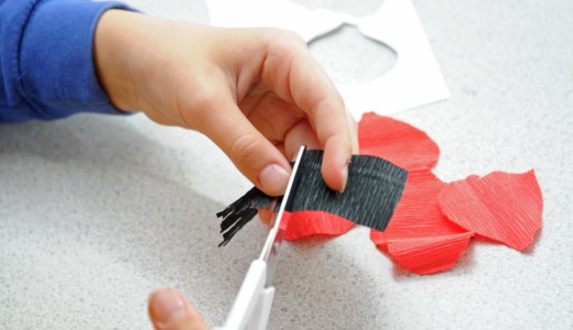 Close up of a child's hands as they cut out the shapes needed to make the paper wildflowers