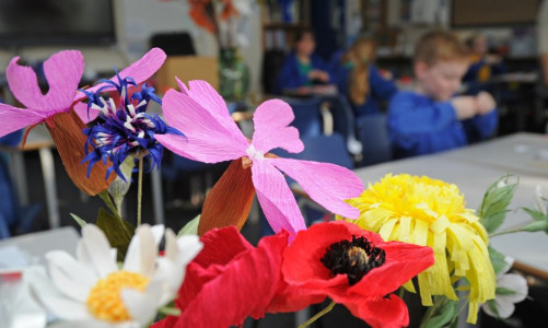 Close up of different types of paper wildflowers including poppies, dandelions and daisies