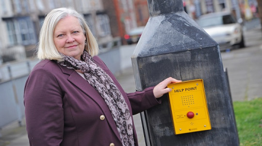 councillor helen camera looking at camera with one hand on yellow help point attached to cctv column