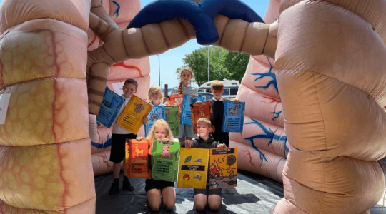 Children from Wirral schools at Eureka! Science + Discovery posing in the middle of some giant inflatable lungs.