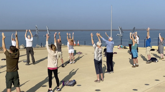 Photo of people taking part in a Qi Gong exercise class on the Old Baths site in West Kirby.