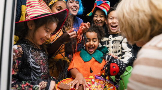 Picture of smiling children in halloween costumes trick or treating