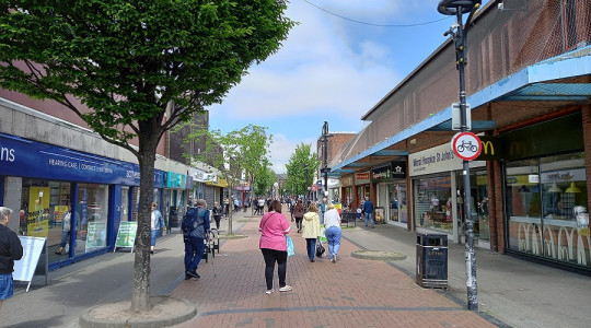 view of liscard way, with shops either side and some shoppers walking away from camera position