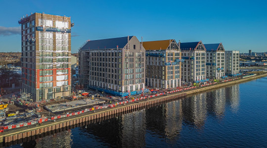 drone shot of partially constructed Miller's Quay, one tall building on the left and five others stretching away on the dockside