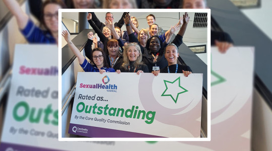 Smiling staff from Sexual Health Wirral hold a sign saying their service is 'outstanding'
