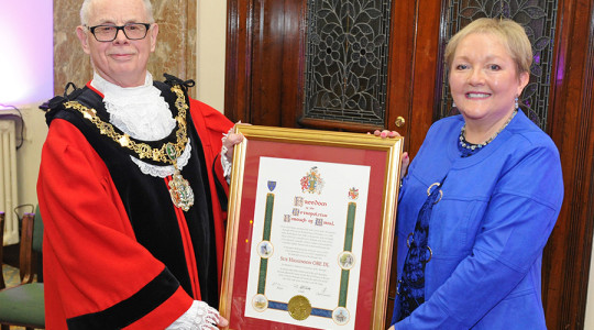 Photo of the Mayor presenting a commemorative scroll to Sue Higginson