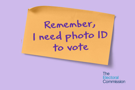 graphic of a post-it note with Remember, I need photo ID to vote written on it.