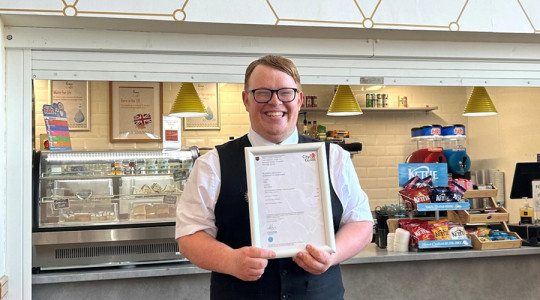 Ben Penny apprentice at floral pavilion smiles holding a certificate