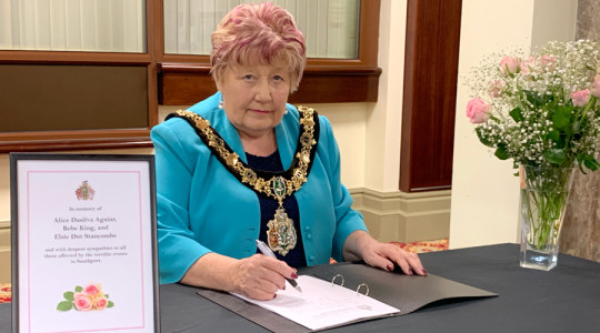 Photo of the Mayor signing a book of condolence