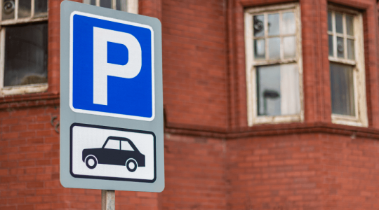 Close up of a car parking sign with a P for parking and an icon of a car underneath