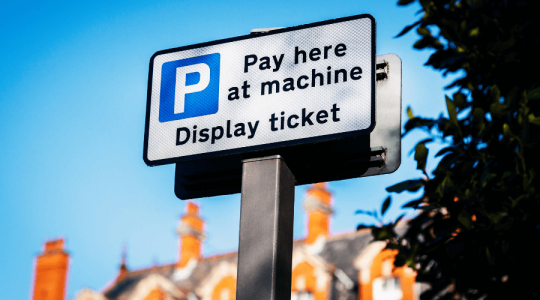 Close up of a parking sign that says 'Pay here at machine' 'display ticket'