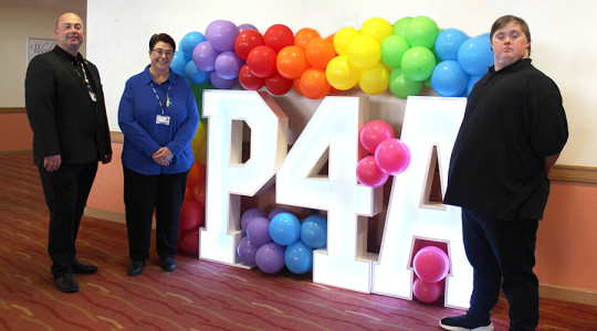 Cllr Paul Stuart, Leader of Wirral Council, and Sandra Costall and her son  Matthew Costall next to the Preparation for Adulthood sign