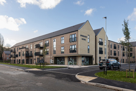 A three storey modern extra care housing facility, with blue sunny sky