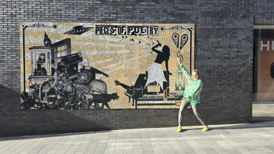 Artist Catherine Rogers poses with the Taylor Swift mural she created