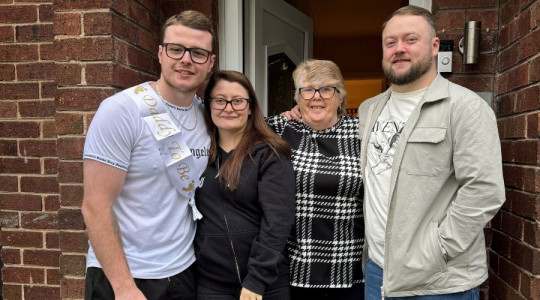 Image of Ashley with her partner and foster family.