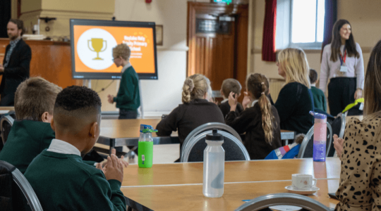 School pupils looking forward in a room as awards are presented 