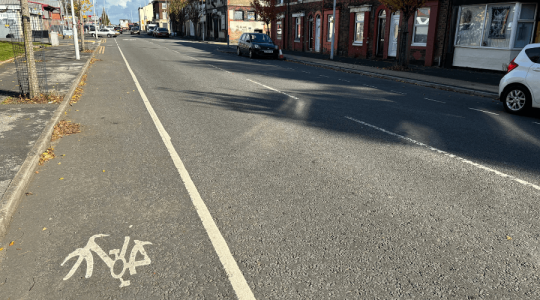 View of a road, where there is a cycle path - but just marked with a white line to separate the cycle lane and road traffic