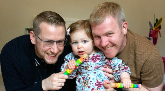 picture of a smiling family two parents and a little girl