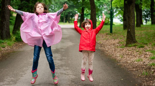 Two children jumping up in park