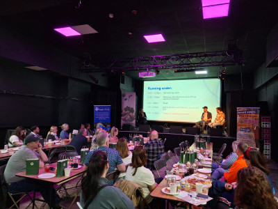 photo of the recoverist launch event with attendees on long tables looking at a screen