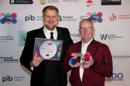 Award winners Wallasey Beach Club hold their trophies in front of a branding board at the Liverpool City Region Tourism Awards