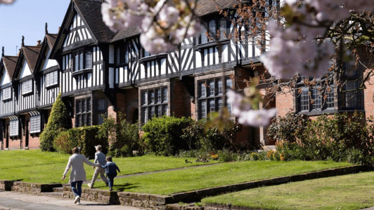 A family walk past historic buildings in Port Sunlight