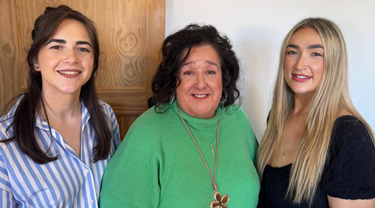 three women smiling to camera