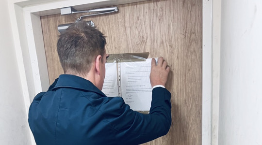 An officer from the anti-social behaviour team serving the Closure Order