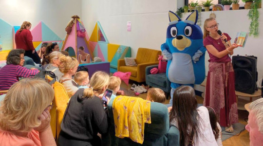 Children with parents, carers and grandparents listening to story time from Bluey