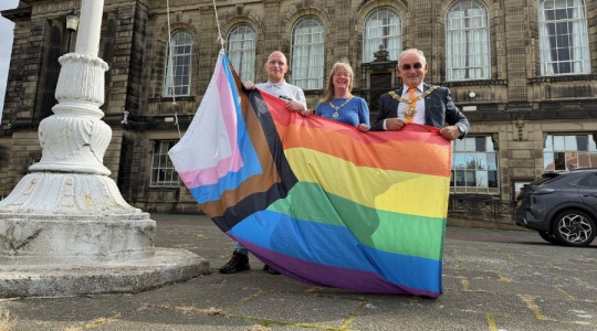 Pic of the mayor raising the pride flag