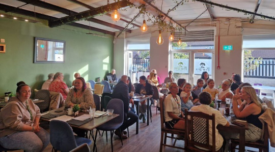 Shot of a busy cafe on their opening day with people sitting down at tables