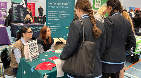 students speak with an exhibitor at careers fair