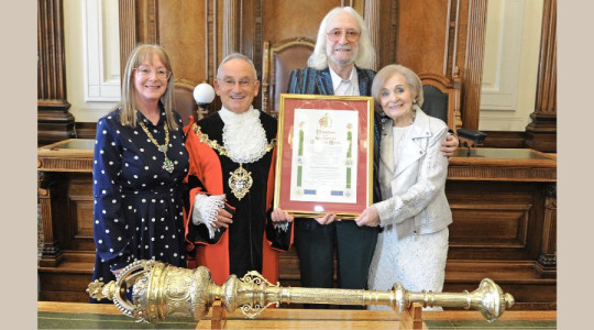 Photo of the Mayor, Mayoress and Charlie and Mrs Lansborough in the Council Chamber holding the scroll