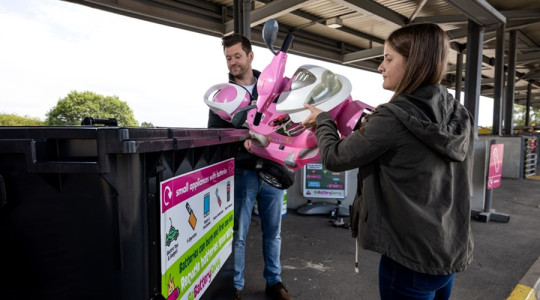 A stock image of a dad and daughter disposing of old toys at their local recycling centre