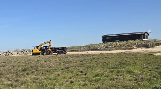 A digger operating on Hoylake beach near the RNLI station
