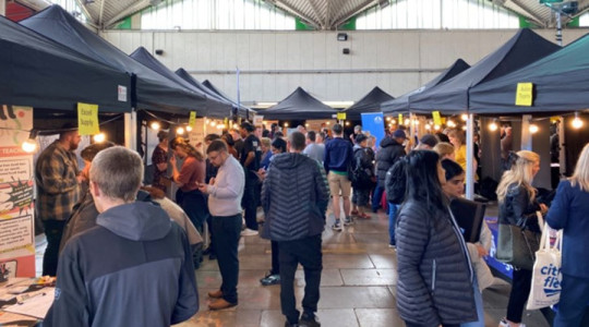Lots of people shown browsing stalls at a jobs fair in Birkenhead Market