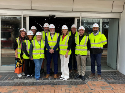 Councillors, traders and construction workers stand outside the former TJ Hughes unit that will become Birkenhead Market wearing high vis jackets and hard hats