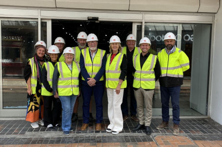 Councillors, traders and construction workers stand outside the former TJ Hughes unit that will become Birkenhead Market wearing high vis jackets and hard hats