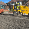 image shows roadworks underway with steamroller following a truck