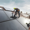 two workmen on a roof installing solar panels