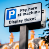 Close up of a parking sign that says 'Pay here at machine' 'display ticket'