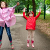 Two children jumping up in park