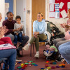 Parents, carers and grandparents sat around in a play session with discussion