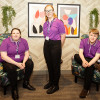 A group students wearing purple Premier Inn polo shirts and black trousers.