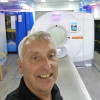 selfie style picture of a man standing in front of a ct scanning machine